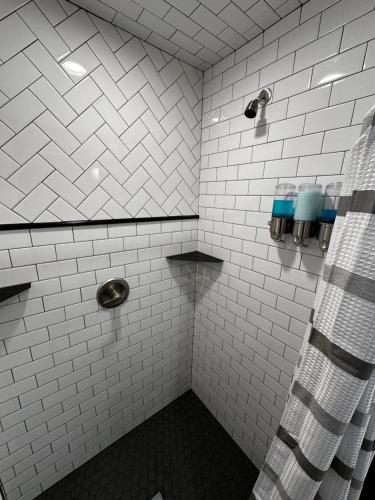 eine weiß geflieste Dusche mit Duschvorhang im Badezimmer in der Unterkunft My Studio in Lovell