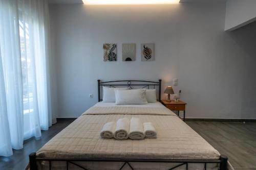 a bedroom with a bed with two towels on it at Villa Papazoglou in Neos Pirgos