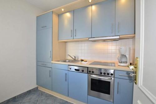a kitchen with blue cabinets and a sink at Birgit, App 4 "Sterntaucher" in Westerland