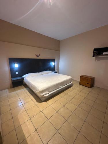 a bedroom with a white bed and a wooden cabinet at La Casa del Mercado in San Miguel de Allende