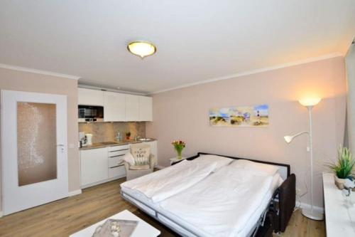 a bedroom with a large bed and a kitchen at Eydum, App 45 in Westerland