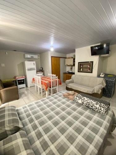 a room with a bed and a kitchen with a table at Casa de descanso, completa, para ate 05 pessoas in Pântano Grande