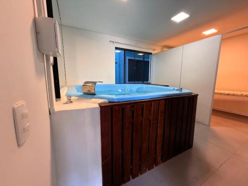 a bathroom with a blue tub in a room at Hotel Mais Lazer - Hotel & Spa in Joinville