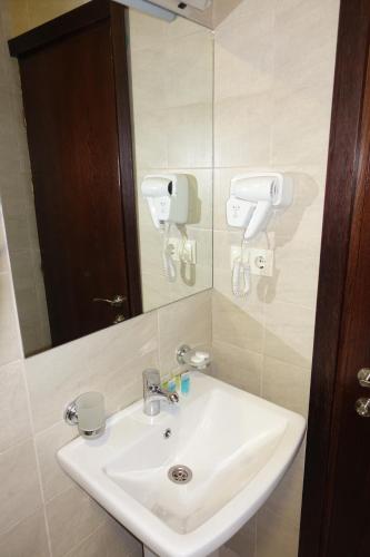 a bathroom with a white sink and a mirror at Metekhi Stay - Old Tbilisi in Tbilisi City