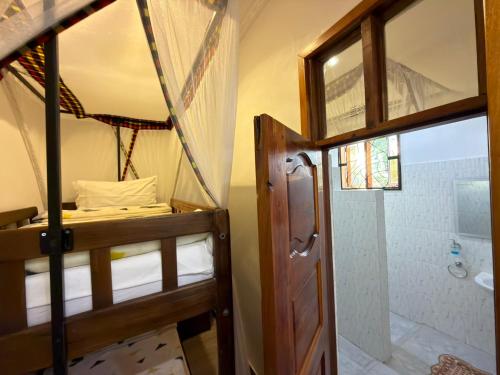 a room with two bunk beds and a shower at Sophie Homestay in Moshi