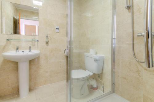 a bathroom with a toilet and a sink and a shower at Wayford Bridge Inn Hotel in Stalham