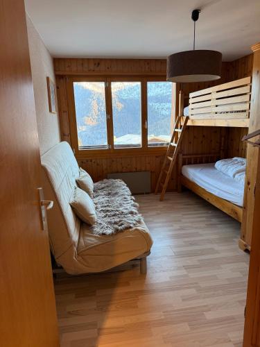 a room with a bunk bed and a couch at Appartement au pied des télécabines in La Tzoumaz