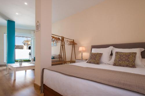 a bedroom with a large white bed with pillows at Hommyhome Pozo Santo Penthouse in Seville