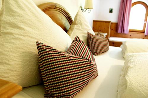a bed with four pillows on top of it at Landhaus Sabine in Zellberg