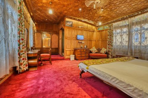 a bedroom with a bed and a desk at Alexandra Houseboats in Srinagar