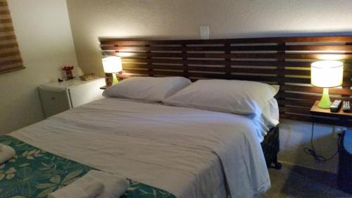 アグアス・デ・リンドイアにあるVista da Serra Pousada de Águasの大きな白いベッドと2つのランプのある寝室