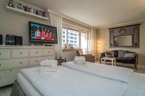 a bedroom with two beds and a flat screen tv at Andreas-Dirks-Straße 1, App 505 "Pralinchen" in Westerland