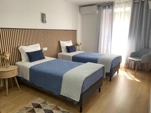 a hotel room with two beds and a window at CASA do AÇÔR in Aldeia das Dez