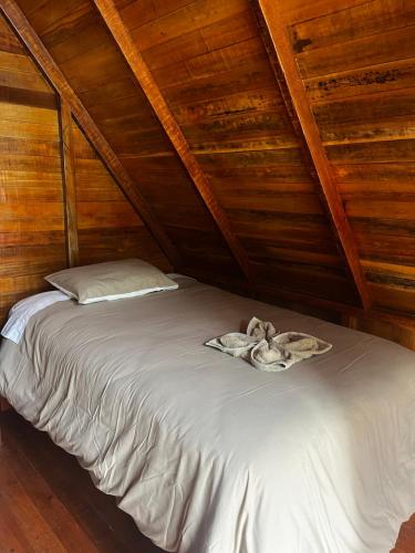 a bed in a room with wooden walls at ALPHINA CABINS Qhapaq Ñan in Sahuayacu