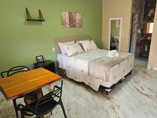 a bedroom with a bed and a table and a table and chairs at Aromas&Brumas Pousada in Brumadinho
