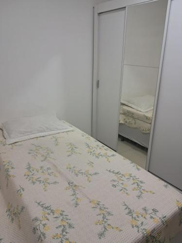 a bedroom with a bed and two mirrors at Apto com área de lazer estilo resort in Parnamirim