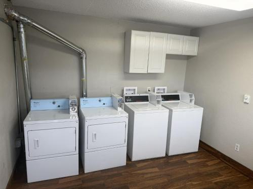 three washers and dryers in a laundry room at Red Roof Inn Detroit - Royal Oak/Madison Heights in Madison Heights