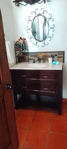 a bathroom with a sink and a mirror on the wall at Summer Nights Oceanfront Villa - Pool & Jacuzzi in Primo Tapia