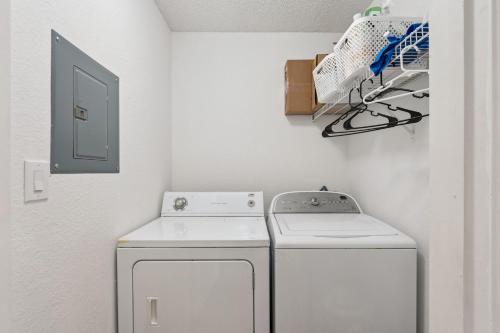 a small laundry room with a washer and dryer at Quiet Gated Condo Near Universal with Pool and View in Orlando