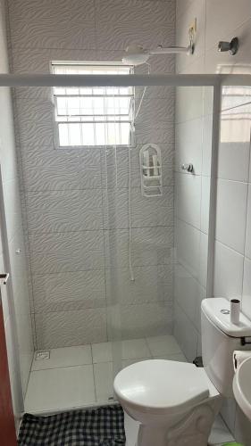 a bathroom with a shower with a toilet and a sink at Casa de Praia com piscina in Mongaguá