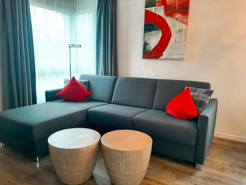 a living room with a blue couch and two red pillows at Ferienwohnung Bergzauber mit Balkon & Bergblick in Schliersee