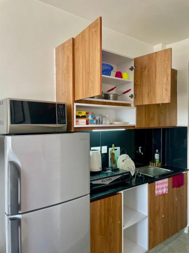 a kitchen with a white refrigerator and a microwave at T-Homes in Nairobi