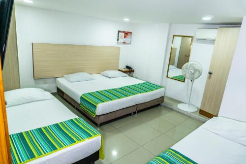 a hotel room with two beds and a fan at HOTEL DON QUIJOTE in Pereira