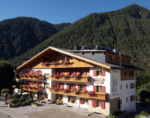 a hotel with flowers on the balconies in front of a mountain at Garni Hotel Residence Diamant in San Vigilio Di Marebbe