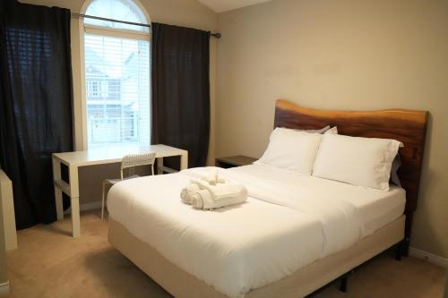 a bedroom with a bed and a desk and a window at Luxury 5BR Home with Spa Bath in Burlington