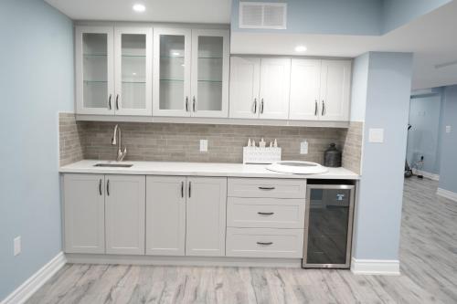 a kitchen with white cabinets and a sink at Luxury 5BR Home with Spa Bath in Burlington