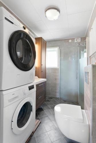 a bathroom with a washing machine and a toilet at Centrum apartment 1 in Ålesund