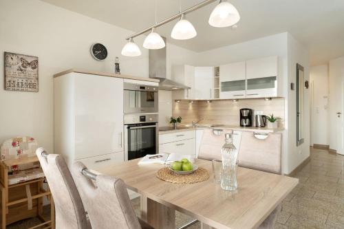 a kitchen with a wooden table with a bowl of fruit on it at Bürgermeister-Fox 42a Meer-Blick in Fehmarn