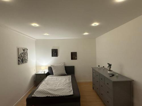 a bedroom with a bed and a dresser at Work & Sleep Am Waldesrand in Vollersode