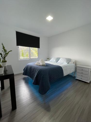 a white bedroom with a bed and a window at Charming hill view retreat in Funchal