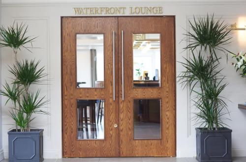 a wooden door with a sign that reads water front lounge at Waterfront Hotel Dungloe in Dungloe