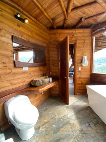 a bathroom with a toilet and a sink at Glamping Corazón del Molino in Ubaque