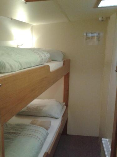two bunk beds in a small room with a window at Zeilschip De Vrouw Dina in Leiden