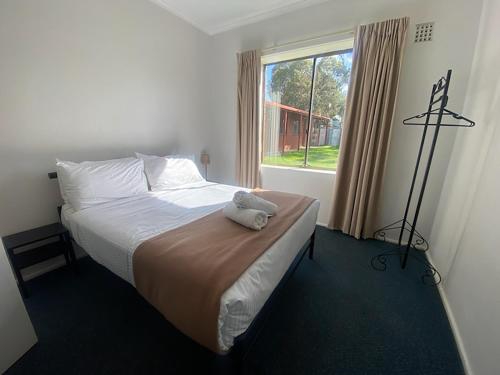 a bedroom with a bed with a stuffed animal on it at Victor Harbor Holiday Park in Victor Harbor