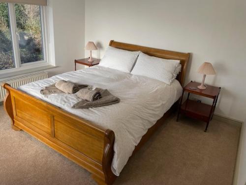 a bed in a bedroom with two nightstands and two lamps at Escape to Blacksmiths Cottage in Cuckfield