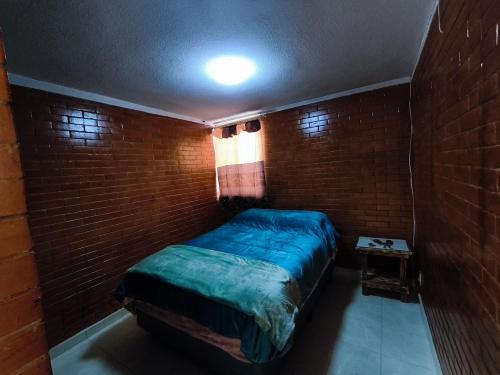 a small bedroom with a bed in a brick wall at Alojamiento en Tlaxco in Tlaxco de Morelos