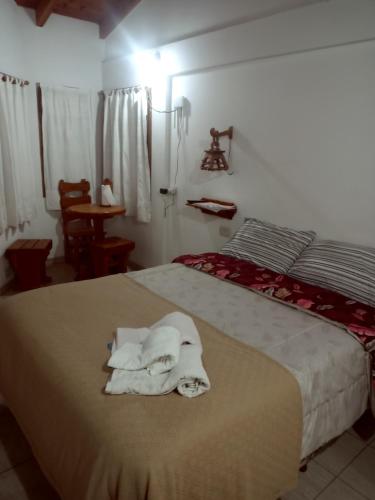 a bedroom with a bed with towels on it at Suites Piltri in El Bolsón