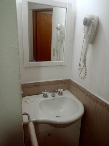 a bathroom with a sink and a mirror and a phone at Suites Piltri in El Bolsón