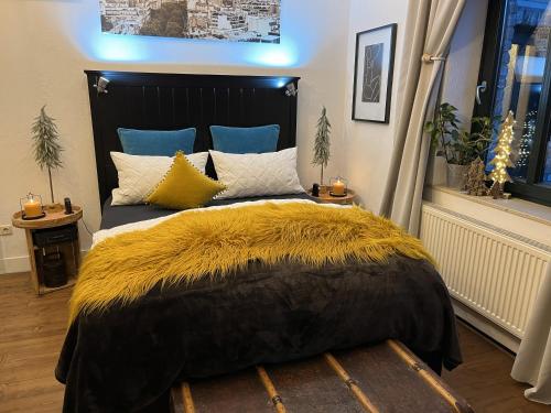 a bedroom with a large bed with yellow and blue pillows at Boutique Apartment Benz 2 in Bergisch Gladbach