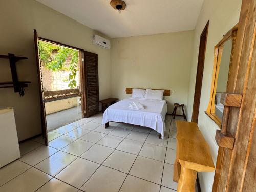 a bedroom with a white bed and a window at Pousada Vila Verde in Olivença