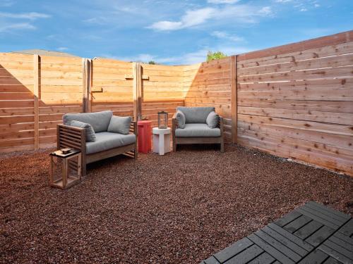 two chairs sitting in front of a wooden fence at Midcentury Couples Designer Loft - Casa Tuya in Austin