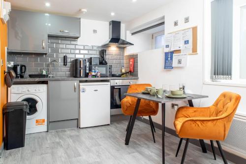a kitchen with a table and two chairs and a sink at Studio Close To Alhambra And Bradford Live Walk To Stations in Bradford