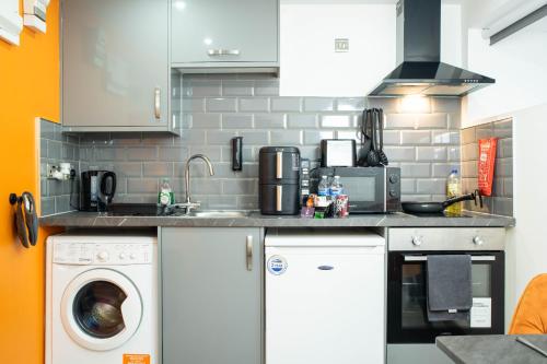 a kitchen with a sink and a washing machine at City Centre Studio With Self Check-In Washer Dryer WiFi & Netflix in Bradford