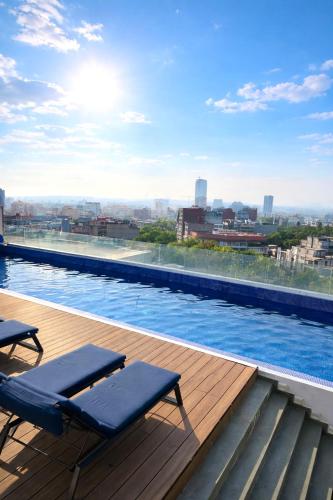 a swimming pool with two lounge chairs on a building at Exclusive 3BR in Condesa - Rooftop Pool - 24h Security in Mexico City
