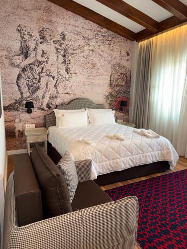 a bedroom with a bed and a chair and a couch at Hani i Gjelit Hotel, Korce in Korçë
