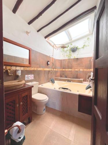 a bathroom with a tub and a toilet and a sink at Casa Real Barichara in Barichara